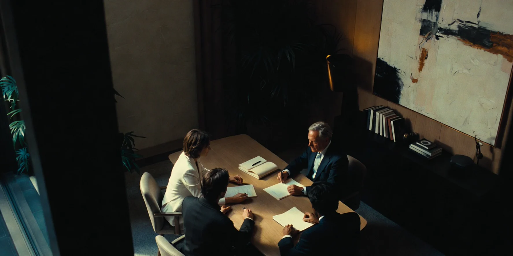 High-angle compliance consultancy meeting in a quiet suite with courtyard views