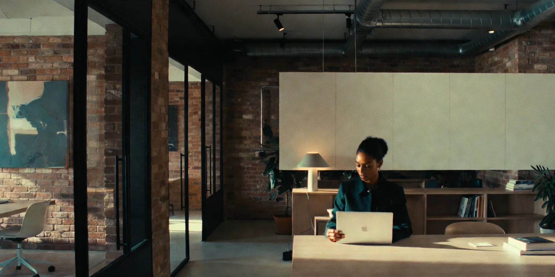 Shoreditch-style regtech office with exposed brick, glass meeting rooms, and a deep corridor