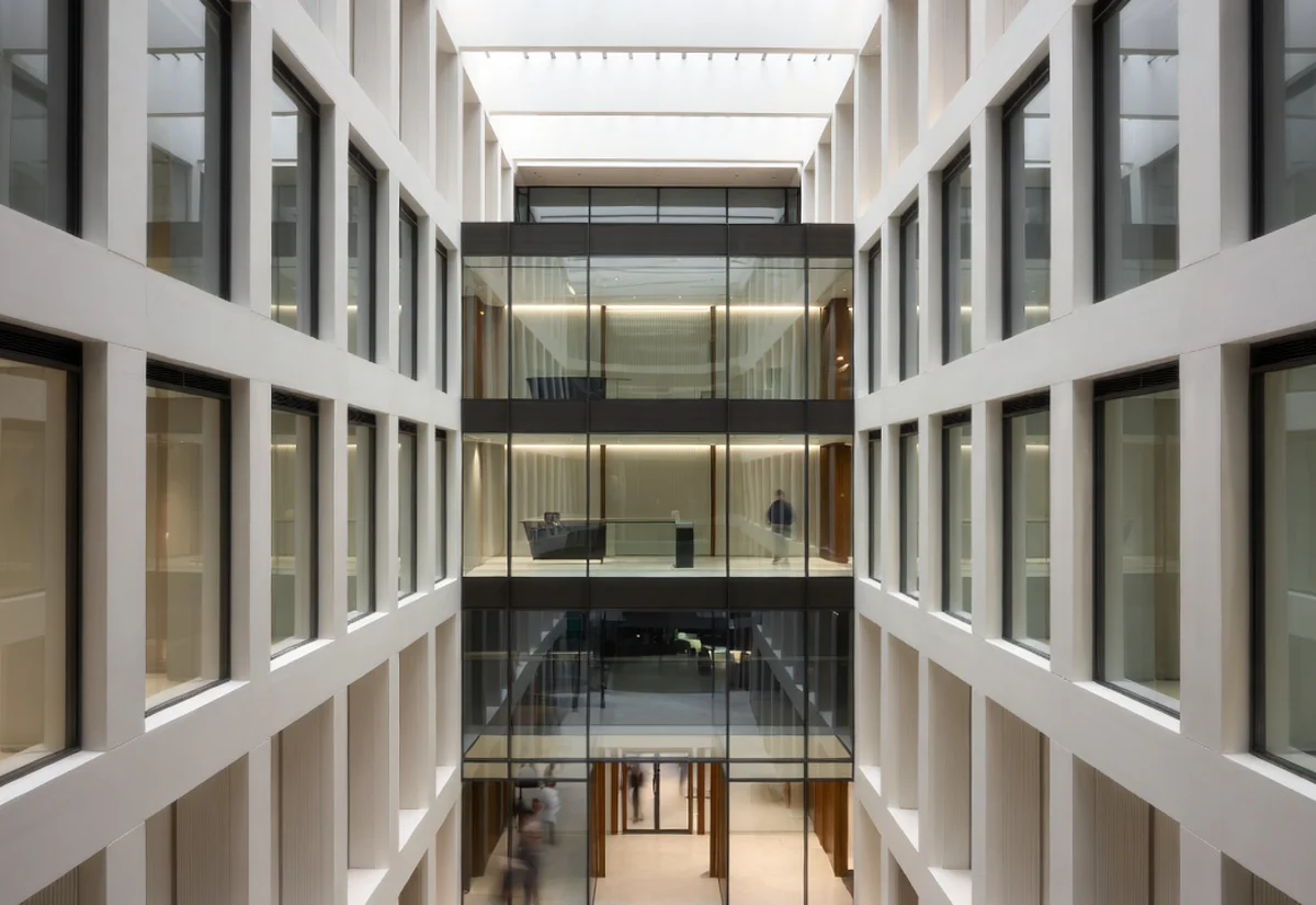 Premium regulatory-hosting atrium with glass-fronted private suites and a mezzanine
